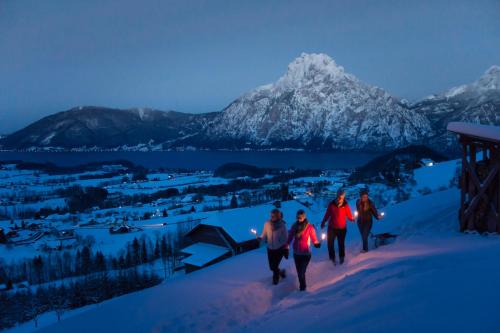 a group of people walking down a snow covered mountain at Das Traunsee - Das Hotel zum See 4 Stern Superior in Traunkirchen