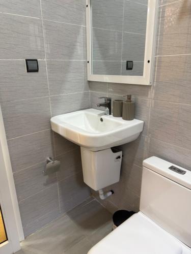 a bathroom with a sink and a toilet and a mirror at Appartement Kekely in Yovo Kopé