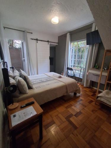 a bedroom with a large bed and a table at Die Eend Studio in Centurion