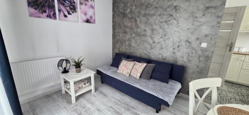 a living room with a blue couch and a table at Apartament Nowe Maniowy in Maniowy