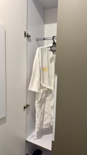 a white shirt is hanging in a closet at Sim Plaza Hotel in Ejmiatsin