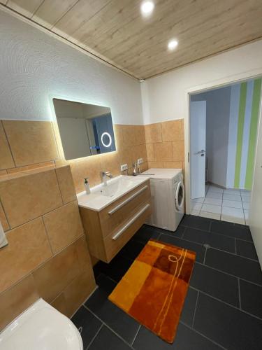 a bathroom with a sink and a washing machine at Ferienwohnung Karin in Losheim