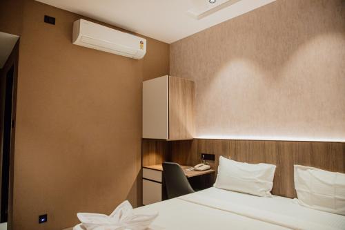 a hotel room with a bed and a desk at Varanashi Inn in Tiruppūr
