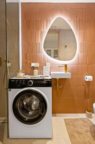 a washing machine in a bathroom with a mirror at Marienholm Seaside Studio in Haapsalu