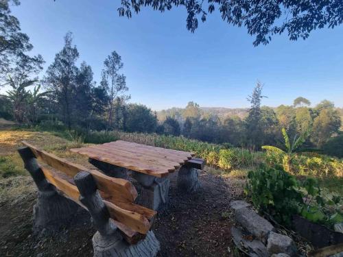 a wooden picnic table sitting in the middle of a field at Karen Little Paradise, ECO Garden Hotel & Farm in Nairobi