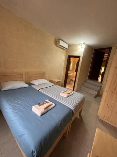 a bedroom with a bed with two towels on it at Serenity Wellness Farmhouse With Private Sauna in Nadur
