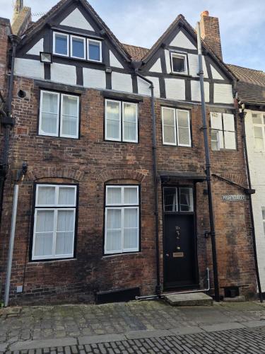a brick house with a black door on a street at Stay in History 13th Century Gem in Central Shrewsbury! in Shrewsbury