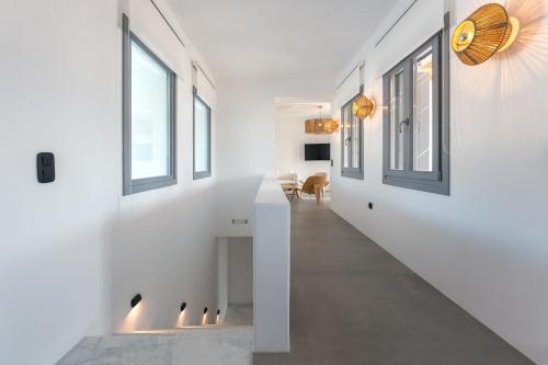 a hallway of a house with white walls and windows at Double Pool Villa Ι in Kampos Paros