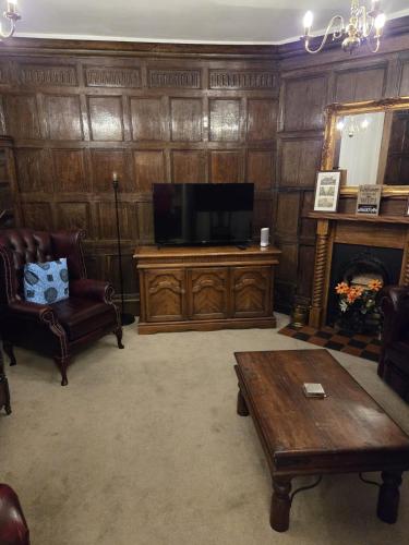 a living room with a television and a fireplace at Stay in History 13th Century Gem in Central Shrewsbury! in Shrewsbury