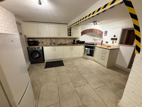 a kitchen with white cabinets and a tile floor at Stay in History 13th Century Gem in Central Shrewsbury! in Shrewsbury
