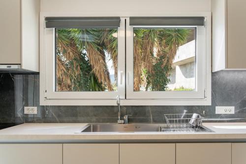 a kitchen with a sink and two windows at M P A Luxury Apartment Α2 in Agios Nikolaos