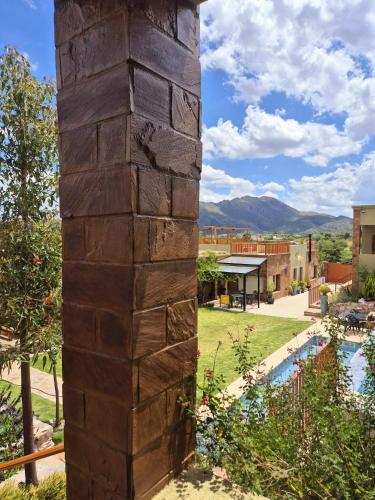 a column in the middle of a yard with a pool at Las Cabras Complejo Turístico in Potrero de los Funes