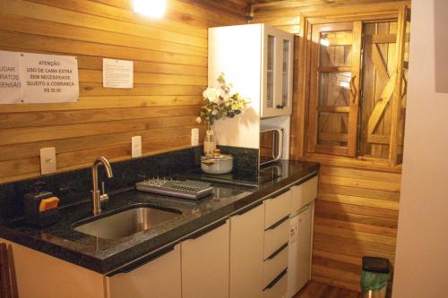 a kitchen with a sink and a counter top at Pousada Cascata Véu de Noiva in Urubici