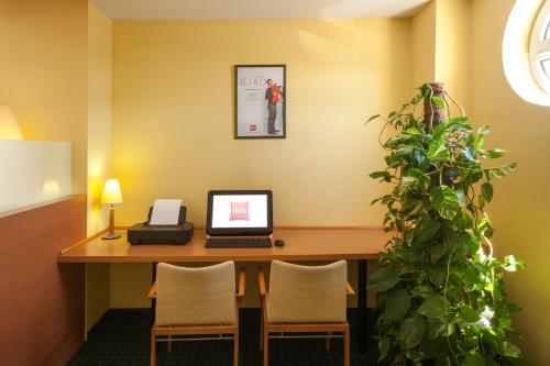 an office with a desk with a laptop and a plant at Ibis Murcia in Murcia