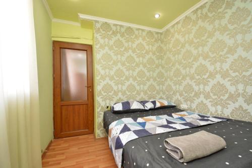a bedroom with a bed with a blue and white comforter at Apartment On Saryan Street in Yerevan