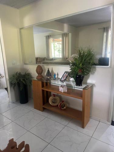 a bathroom with a vanity with a large mirror at Sitio encantos do vale Casa in Major
