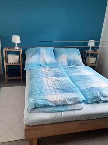a bed in a room with a blue wall at Ferienwohnung Panorama in Konz