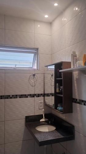a bathroom with a sink and a window at Acomodações em Bananeiras, PB in Bananeiras
