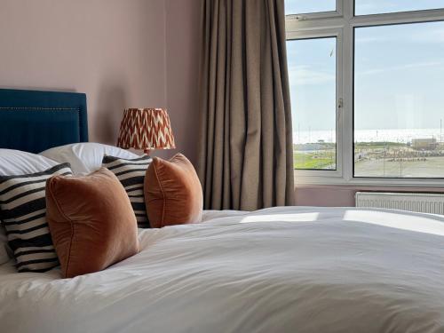 a bedroom with a bed and a large window at East Beach Guest House in Littlehampton