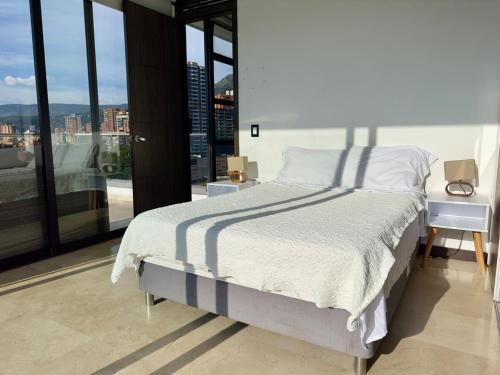 a bedroom with a bed and a large window at 2003 Poblado TOP apartamento in Medellín