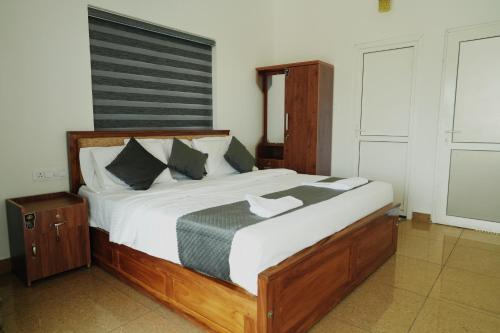 a bedroom with a large bed with white sheets at Samudra Retreats Vagamon in Vagamon
