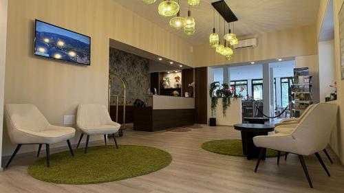 a waiting room with chairs and a tv on the wall at Hotel Bel Sito Peschiera in Peschiera del Garda