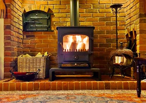 a brick fireplace in front of a brick wall at The Ultimate Romantic Getaway! Cosy Cottage surrounded by Wildlife with Lakeside views, Log Burner & miles of Sandy Beach on your Doorstep! All at the Best Location in Mablethorpe! For that "Special" Seaside experience! in Mablethorpe