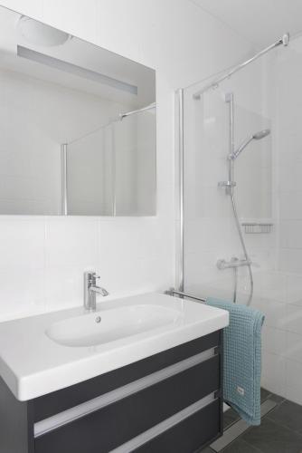 a white bathroom with a sink and a shower at Veerse Muze in Kamperland