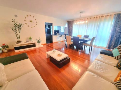 a living room with a couch and a dining room at Spacious Summer Fresh Family Apartment with Panoramic Sea Views in Funchal in Funchal
