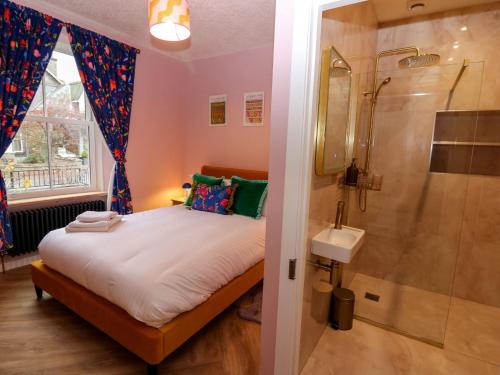 a bedroom with a bed and a shower and a sink at Lindean in Ballater