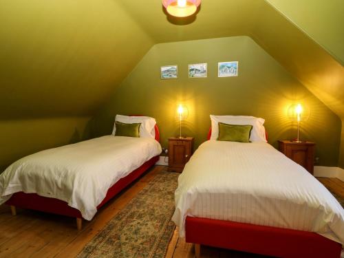 two beds in a room with green walls at Lindean in Ballater