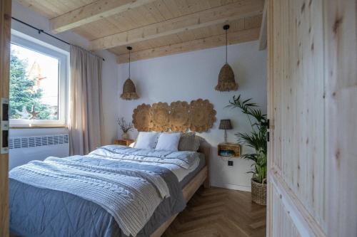 a bedroom with a large bed with a wooden headboard at Krukówka Białogóra & jacuzzi in Białogóra