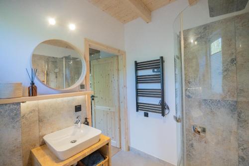 a bathroom with a sink and a mirror and a shower at Krukówka Białogóra & jacuzzi in Białogóra