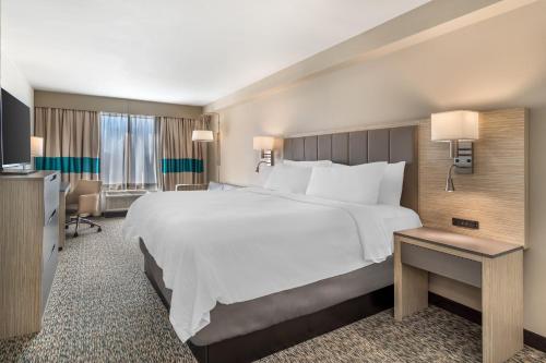 a large white bed in a hotel room at Holiday Inn Knoxville N - Merchant Drive by IHG in Knoxville