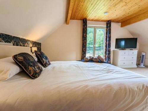 a large white bed in a room with a window at Maple in Knighton