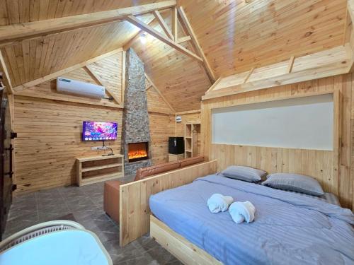 a bedroom with a large bed in a wooden room at Khaoyai Art Tree in Pong Talong