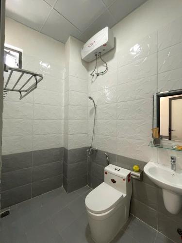 a bathroom with a white toilet and a sink at La Maison DaLat Home in Ấp Kim Thạch