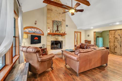 a living room with leather furniture and a fireplace at The Cabin at Rooster Ridge in Fischer