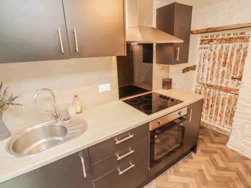 a small kitchen with a sink and a stove at 25 Low Seaton in Workington
