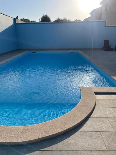 a large blue swimming pool on the side of a building at Volme home in Banjole