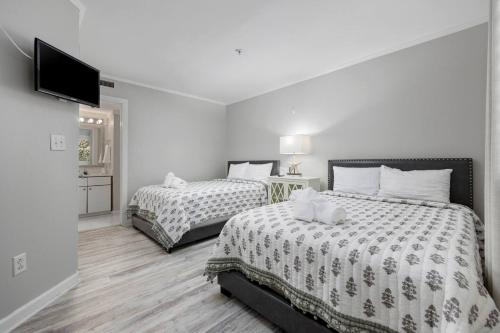 a bedroom with two beds and a flat screen tv at Ocean Creek Amazing Resort Amenities in Myrtle Beach