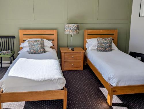 two beds sitting next to each other in a room at The White Hart Inn, Hawes in Hawes
