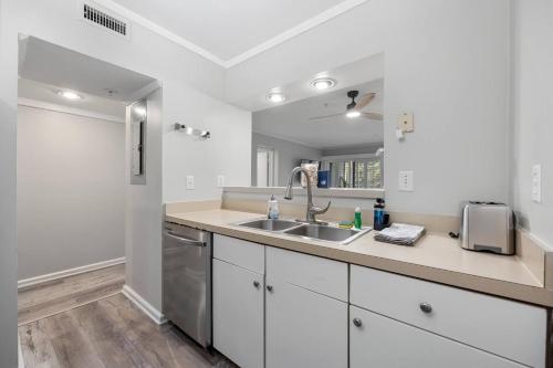 a kitchen with white cabinets and a sink at Ocean Creek Amazing Resort Amenities in Myrtle Beach
