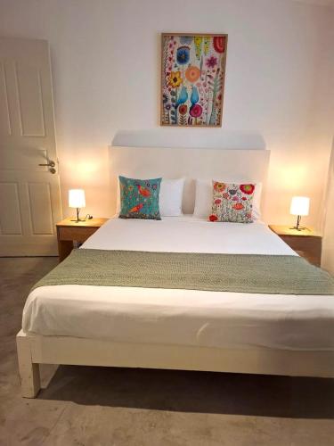 a bedroom with a white bed with two lamps at Nulacaz 2 - Centrally located in Rose Hill