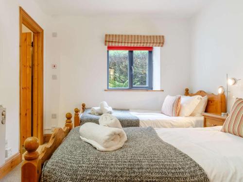 a bedroom with two beds and a window at 3 Bed in Fowey oc-55382 in Golant