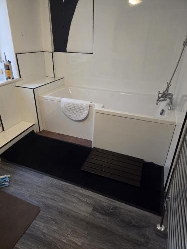 a bathroom with a bath tub with a towel on it at Stay in History 13th Century Gem in Central Shrewsbury! in Shrewsbury
