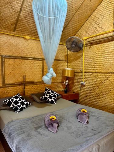a bedroom with a bed with hats on it at Bunga Hut Koh Lanta in Ko Lanta