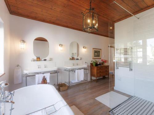 a bathroom with two sinks and two mirrors at Navarre Residence in Stellenbosch