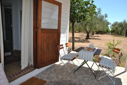 a patio with a table and chairs and a door at La Casetta di Saha in collina in Itri
