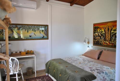 a bedroom with a bed and a desk and a painting at La Casetta di Saha in collina in Itri